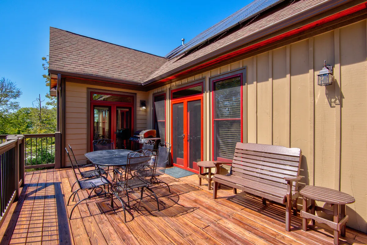 This image showcases an inviting outdoor seating area with a dining table set on a patio, surrounded by lush greenery. The scene conveys a relaxed, social atmosphere, ideal for al fresco meals, unwinding with a book, or gathering with friends and family against a backdrop of natural beauty.